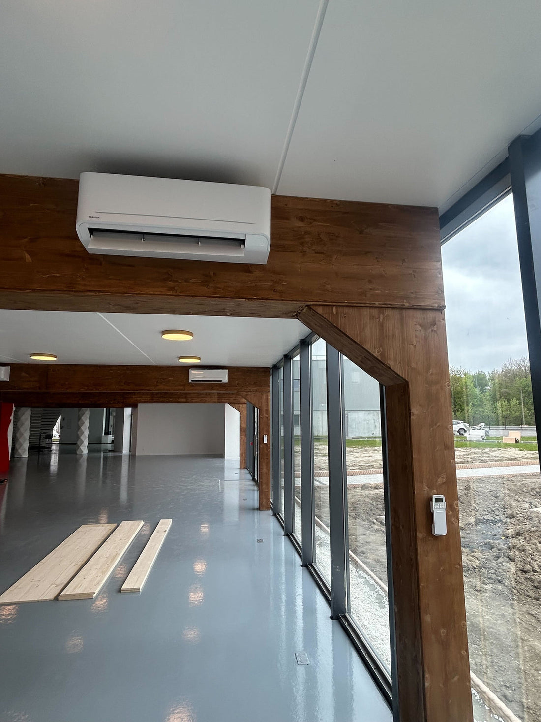 Bâtiment professionnel en rénovation avec vitrages, structure bois et équipements techniques