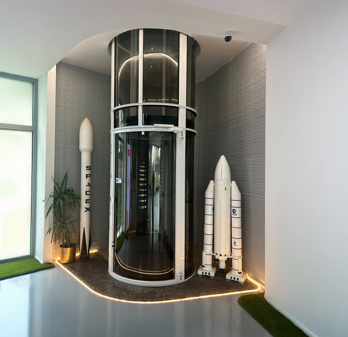 Espace intérieur avec ascenseur vitré et murs texturés en béton imprimé